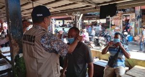 Dinas Perdagangan OKI saat memasangkan masker ke pedagang Pasar Kayuagung, Jumat (25/6)